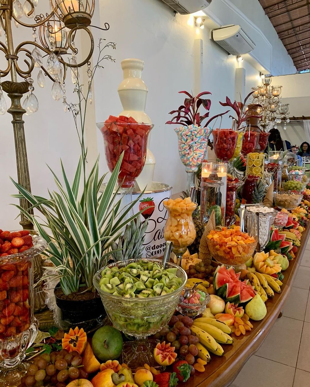 Cascata de chocolate em evento com frutas e doces